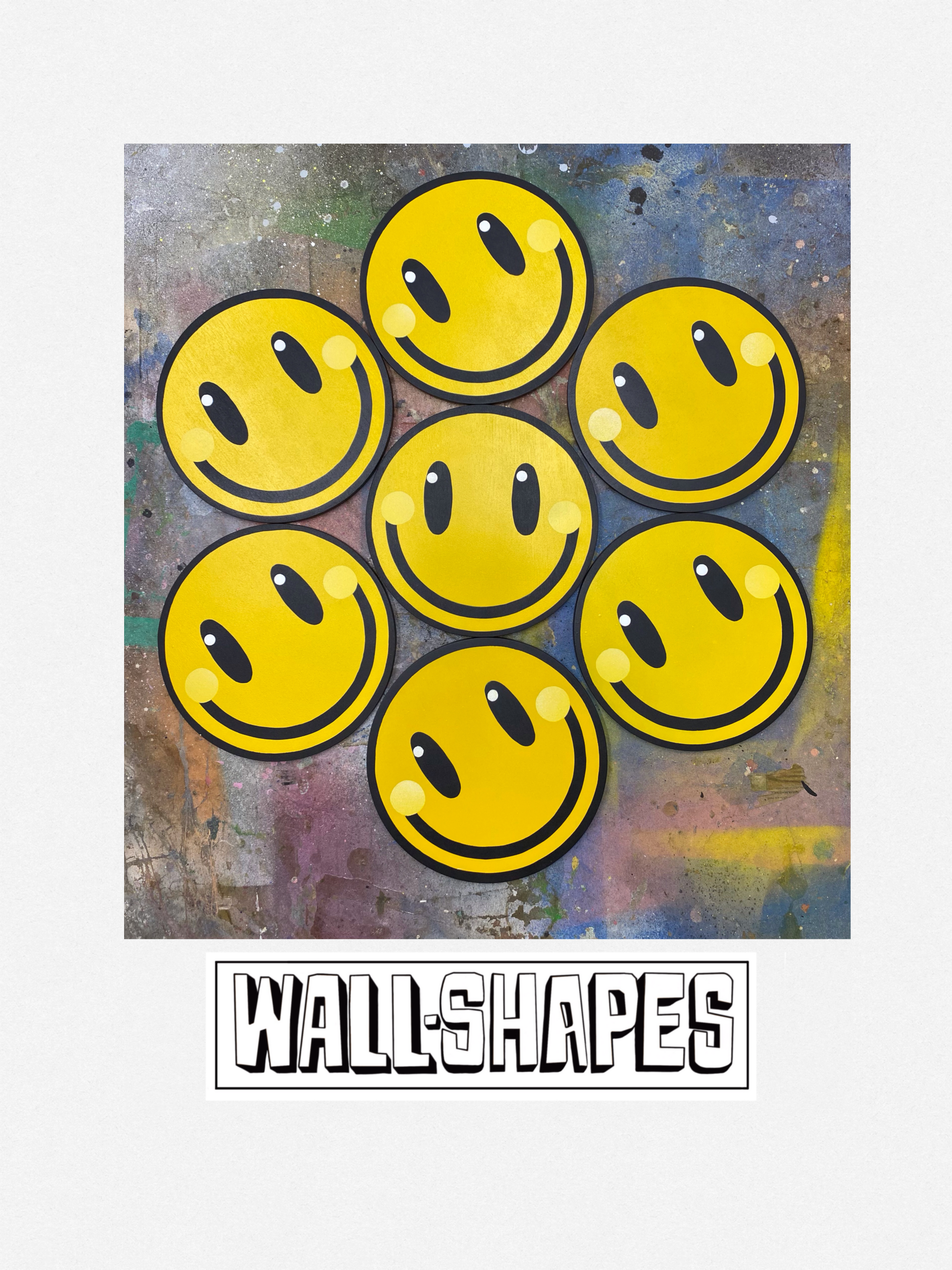 A photo of a collage displaying seven smiley face spray painted wall art pieces on a spray painted background with 'WALL-SHAPES' branding.