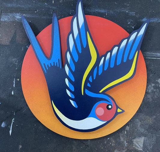 Spray-painted swallow wall art mounted on an orange disk sunset background, removable, handmade by WallShapes UK