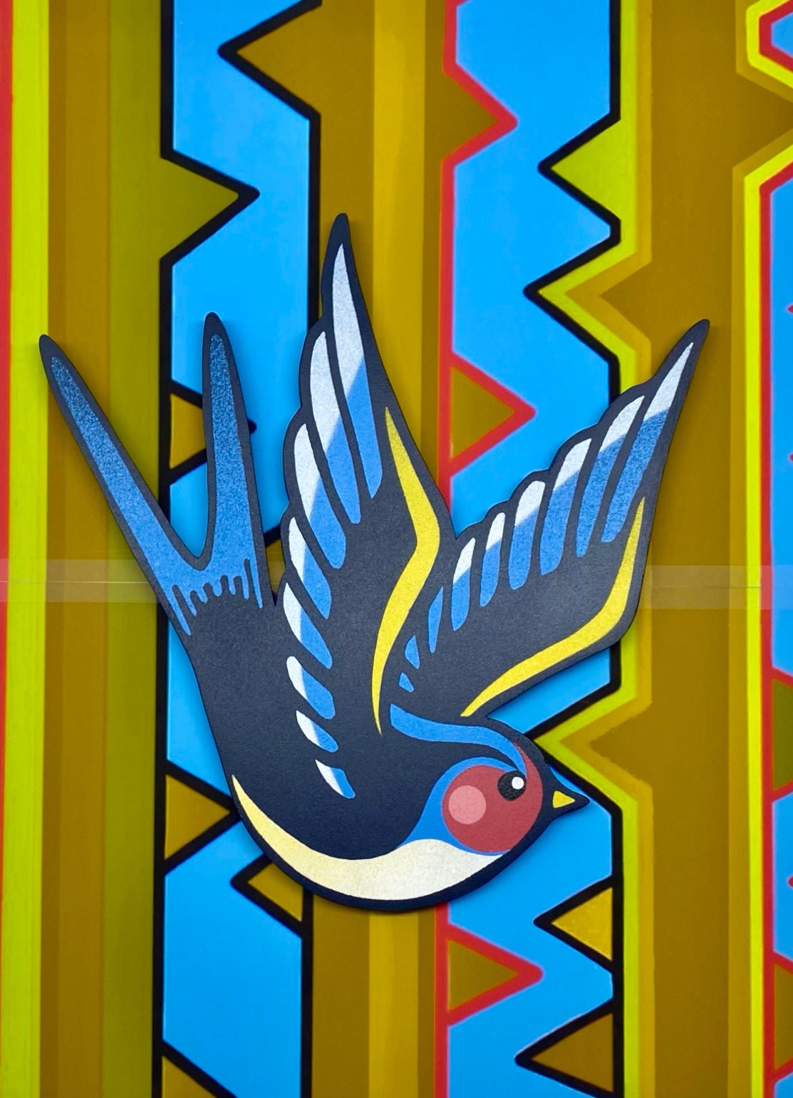 Wooden spray painted swallow bird art on photographed on an uncut stencil.