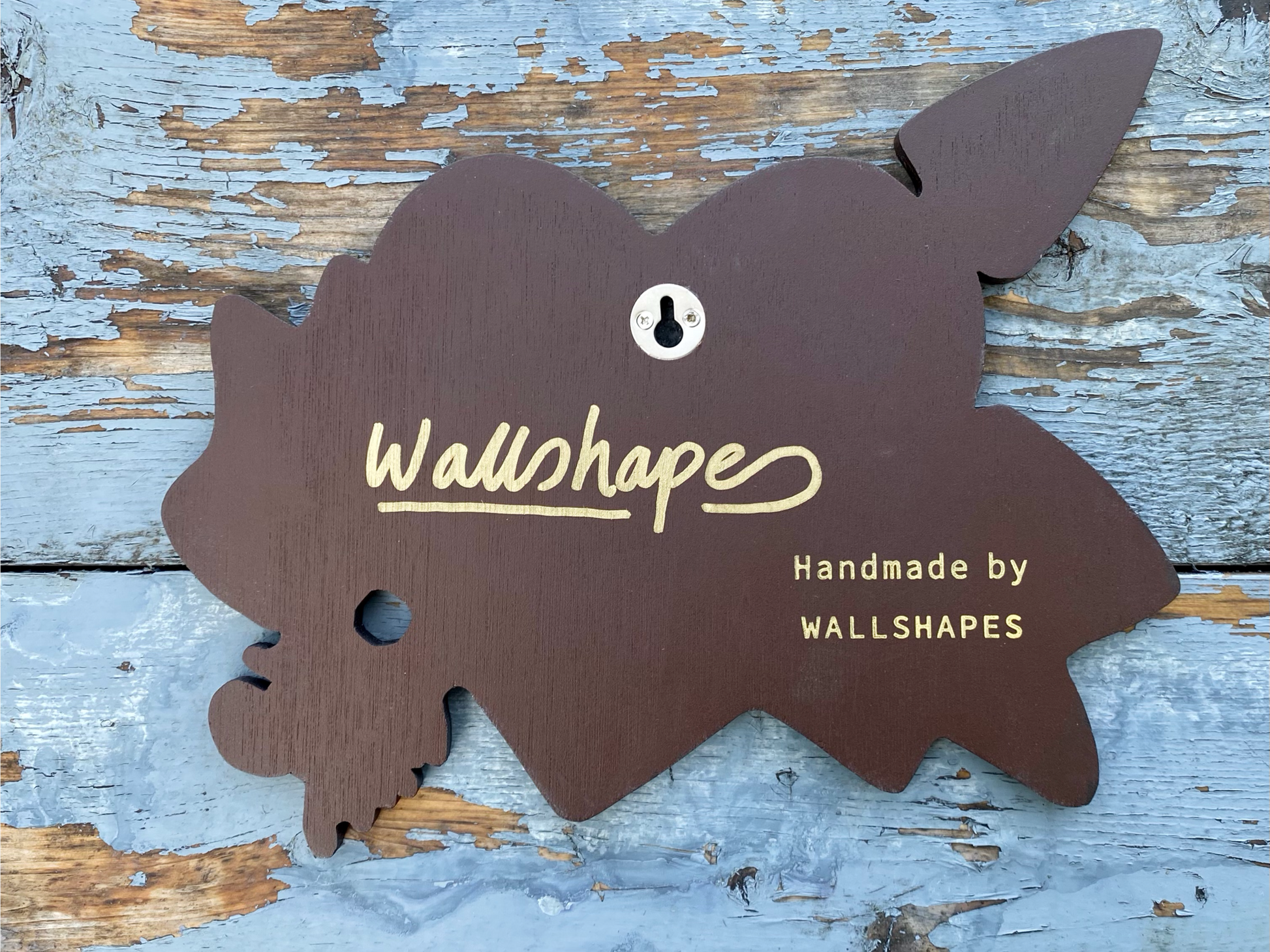 Signed reverse and hanging feature of decorative spray painted, wooden shaped wall art with a red heart, yellow banner, and black TRUE text hanging on a white background.