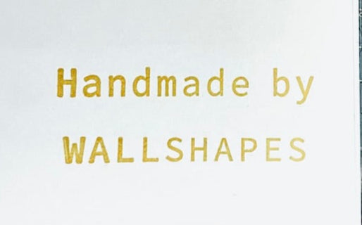 Text 'Handmade by WALLSHAPES' in gold on a white background