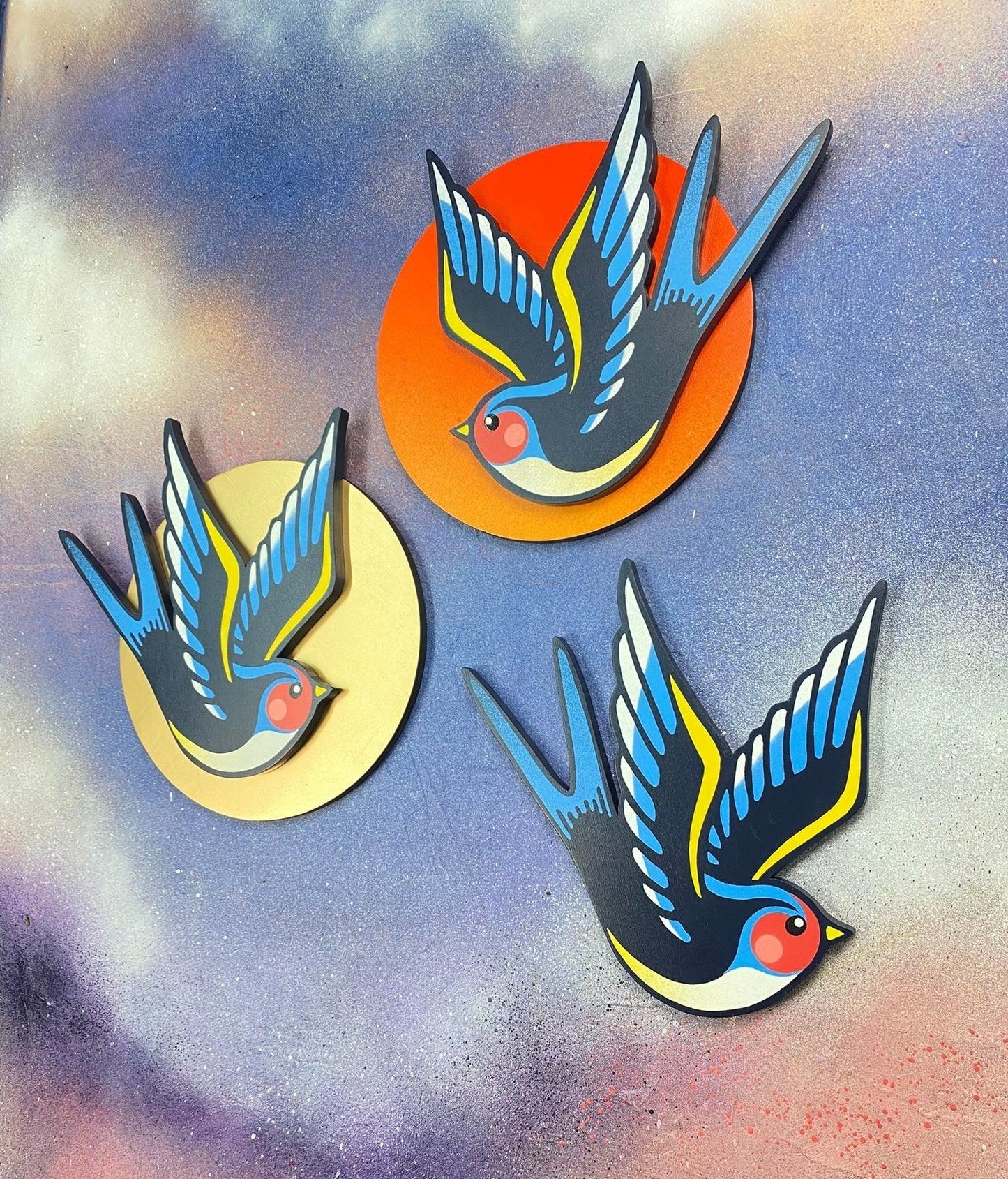 Handcrafted spray-painted swallow wall art on colorful circular backgrounds from WallShapes Shop.