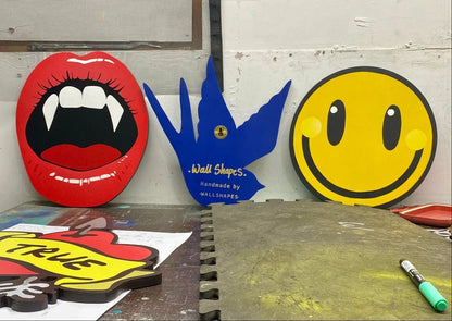 Handmade WallShapes art: spray-painted vampire lips, blue bird, pierced heart and yellow smiley face decor.