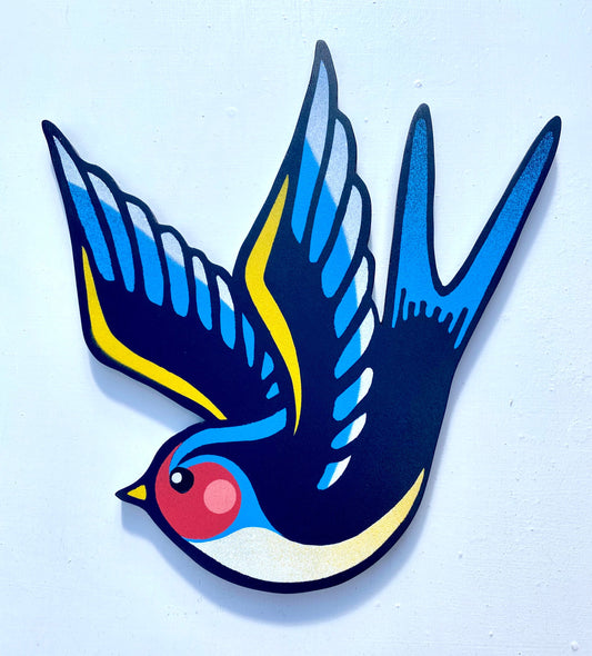 Tattoo inspired, colourful spray painted art, painted on a hand-shaped wooden panel displayed on a white wall.