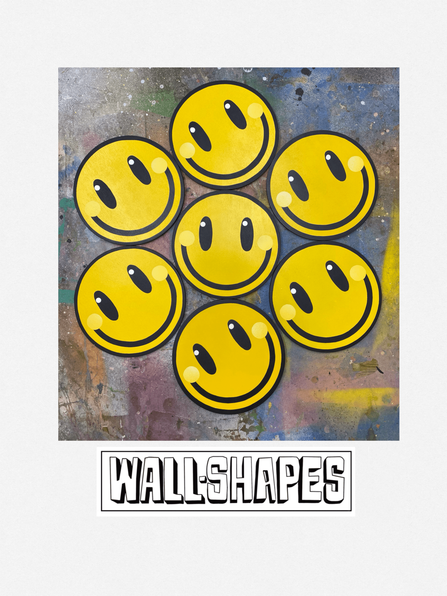 A photo of a collage displaying seven smiley face spray painted wall art pieces on a spray painted background with 'WALL-SHAPES' branding.