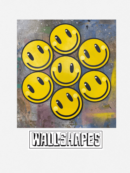 A photo of a collage displaying seven smiley face spray painted wall art pieces on a spray painted background with 'WALL-SHAPES' branding.