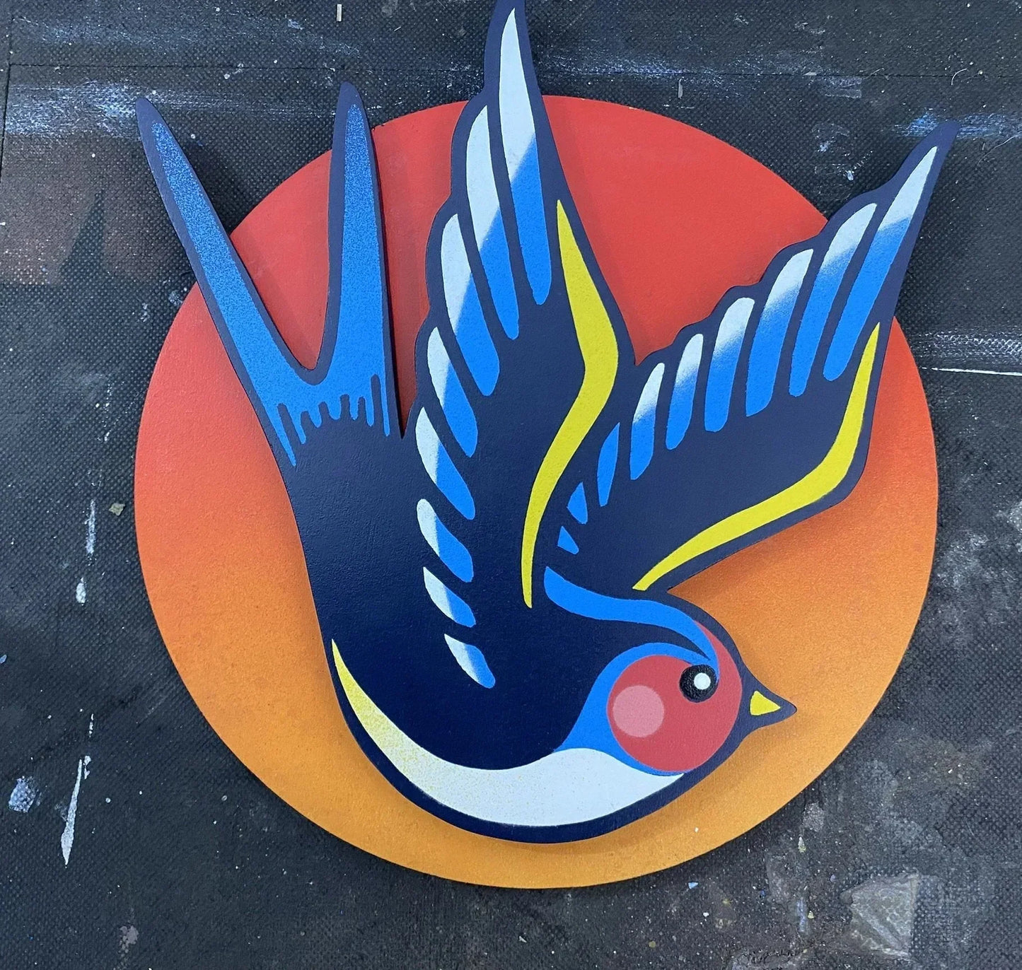 Spray-painted swallow wall art mounted on an orange disk sunset background, removable, handmade by WallShapes UK