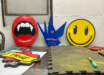 Handcrafted wall art by WallShapes featuring pop art vampire lips, blue swallow, pierced heart and smiley face designs.