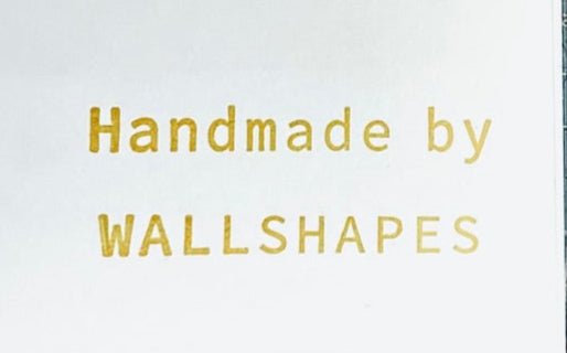 Text 'Handmade by WALLSHAPES' in gold on a white background