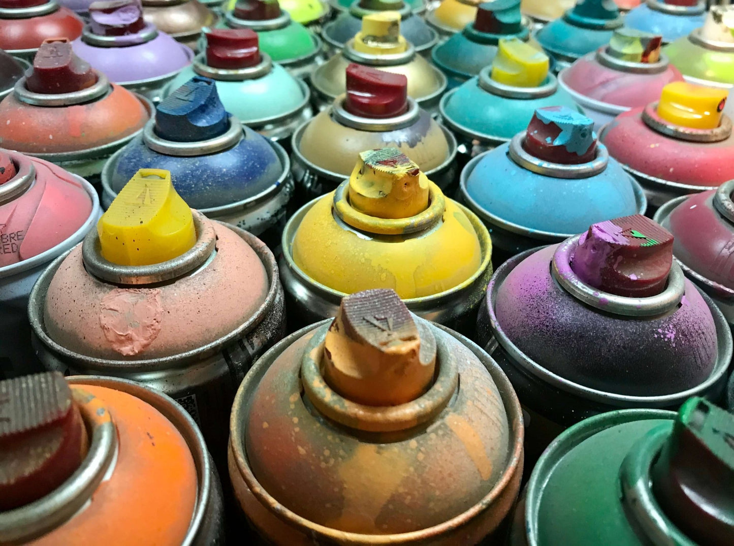 Image of colourful spray-paint cans.