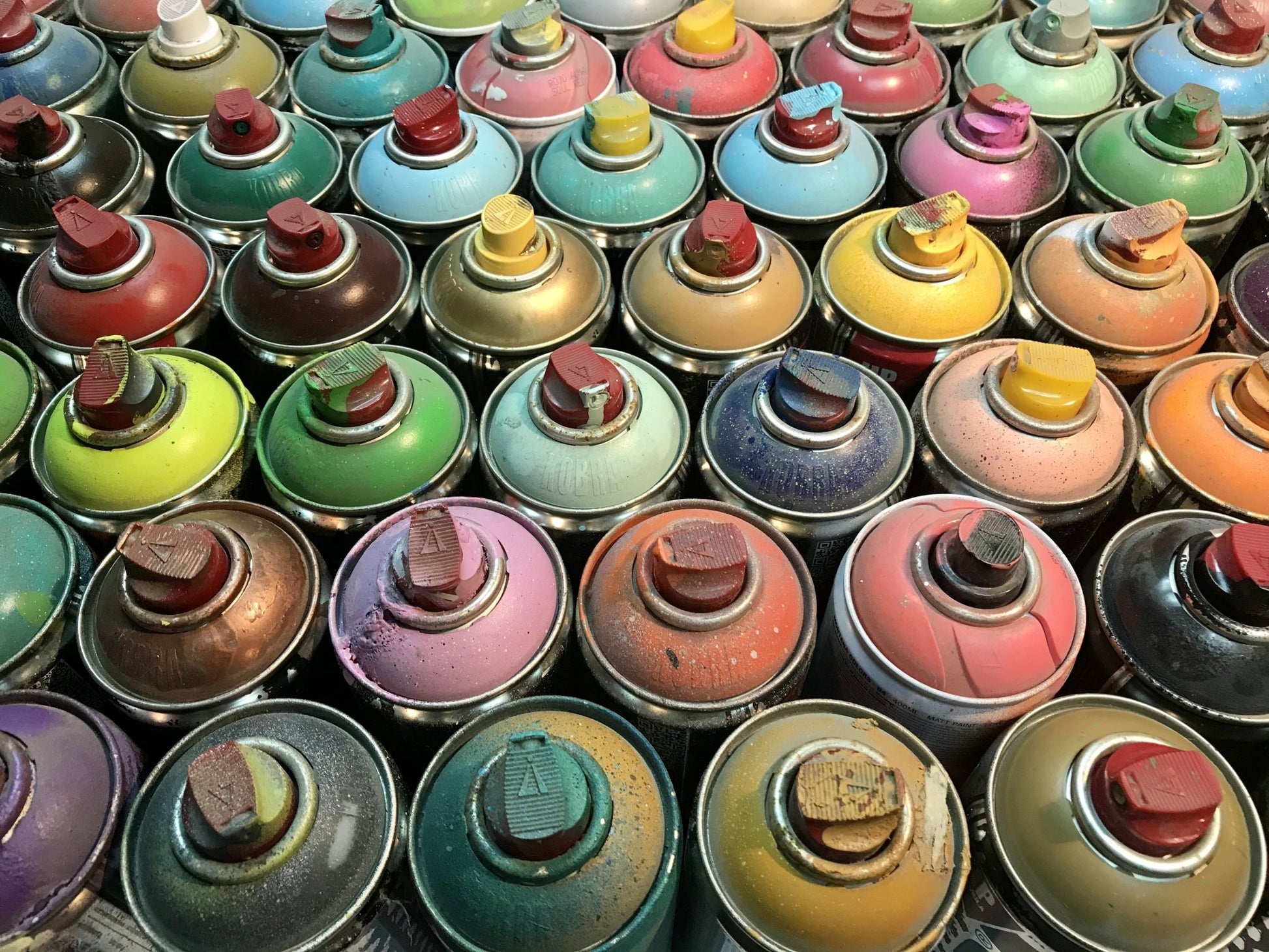 An Image of colorful used spray-paint cans.